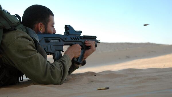 Un soldado israelí dispara arma TAR-21 en un campo de tiro militar en el sur de Israel el 6 de julio de 2009. - Sputnik Mundo