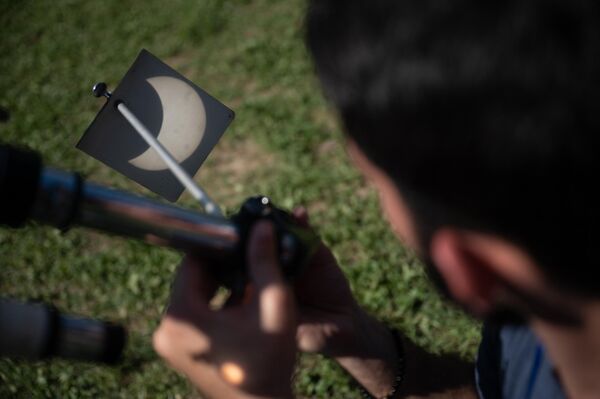 Un hombre observa una proyección del eclipse solar anular en Caracas, Venezuela - Sputnik Mundo
