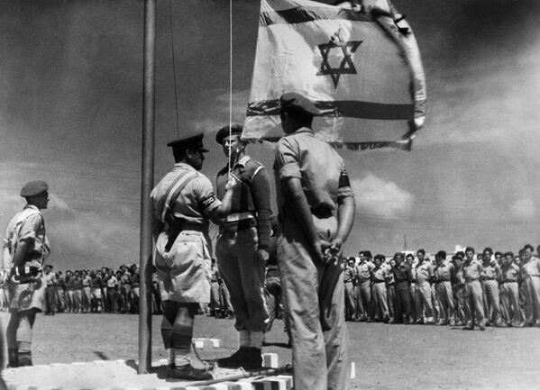 El 14 de mayo de 1948, el Consejo Nacional Judío proclamó la creación del Estado de Israel. El 15 de mayo, el nuevo estado fue reconocido por EEUU y el 17 de mayo por la Unión Soviética.En la foto: la primera ceremonia de izado de la bandera israelí, 1948. - Sputnik Mundo