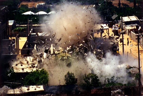 La Intifada se conoce a menudo como la Guerra de las Piedras, porque al principio los palestinos utilizaban básicamente piedras contra los israelíes. Más tarde, empezaron a utilizar también artefactos explosivos improvisados.En la foto: militares israelíes destruyen la casa de Vadan Shaaban Ibrahim Nakusi, palestino de 17 años, líder de un grupo de rebeldes que operaba en Cisjordania, junio de 1989. - Sputnik Mundo