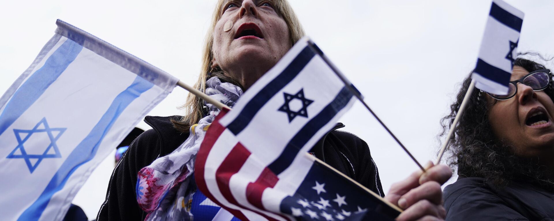 Un simpatizante sostiene banderas israelíes y estadounidenses en un acto de solidaridad en Glencoe, Illinois, 10 de octubre de 2023. - Sputnik Mundo, 1920, 02.02.2024