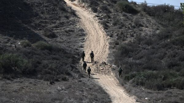 Una imagen tomada desde la frontera entre Israel y Gaza el 21 de octubre de 2023 muestra a soldados israelíes patrullando cerca de la Franja de Gaza. - Sputnik Mundo