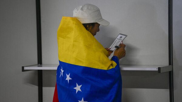 Una mujer ejerce el voto en las primarias venezolanas desde una mesa en el extranjero, concretamente en Bogotá, Colombia - Sputnik Mundo