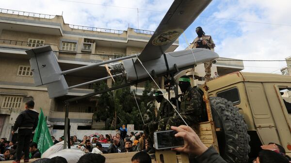 Militantes palestinos de las Brigadas Ezzedine al-Qassam, el brazo armado de Hamás, desembarcan un dron durante un desfile con motivo del 27 aniversario de la creación del movimiento islamista, el 14 de diciembre de 2014 en la ciudad de Gaza. - Sputnik Mundo