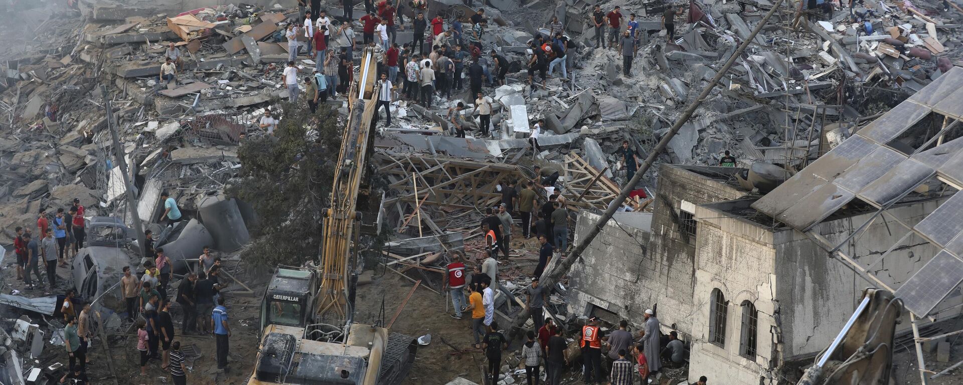 Palestinos inspeccionan los daños de los edificios destruidos tras los ataques aéreos israelíes sobre la ciudad de Gaza, el 25 de octubre, 2023 - Sputnik Mundo, 1920, 26.10.2023