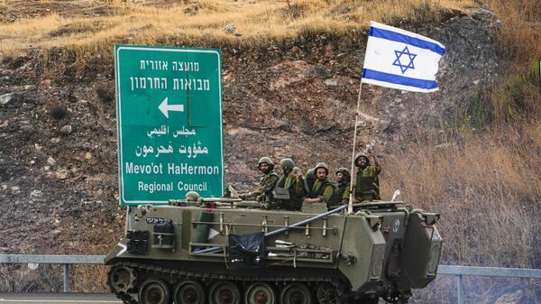 Soldados israelíes conducen un vehículo blindado de transporte de personal cerca de la frontera con Líbano, el 11 de octubre de 2023  - Sputnik Mundo