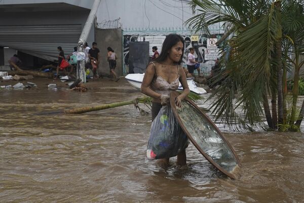 Las lluvias récord provocadas por el huracán continuaron el jueves. En la foto: una habitante de Acapulco sumergida. - Sputnik Mundo