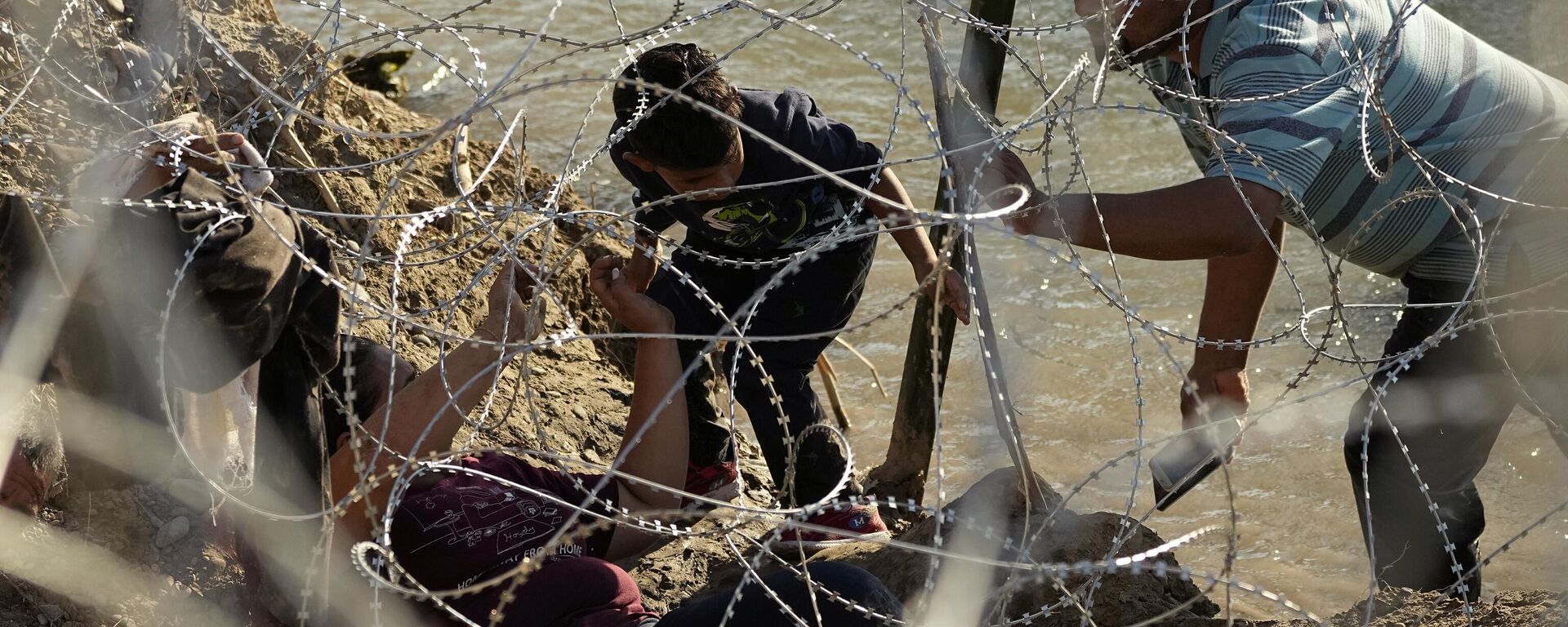 Migrantes tratando de cruzar la frontera entre México y Estados Unidos  - Sputnik Mundo, 1920, 30.10.2023
