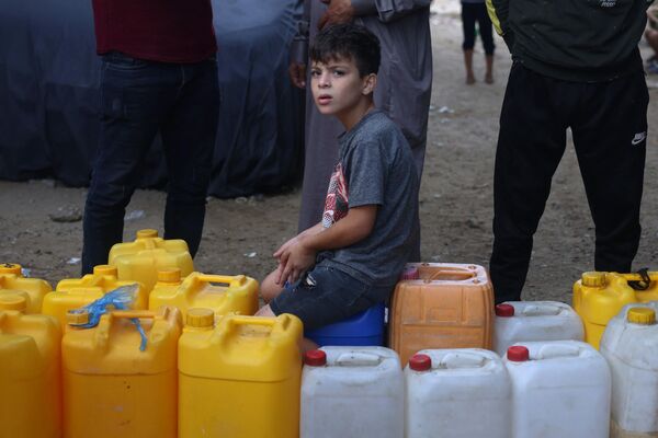 Las autoridades israelíes, en respuesta al ataque de Hamás el 7 de octubre de este año, comenzaron a bombardear la Franja de Gaza, arrasando viviendas y mezquitas donde los israelíes creen que los combatientes de Hamás almacenan armas.En la foto: un niño palestino hace fila para conseguir agua en la ciudad de Rafah, en el sur de la Franja de Gaza. - Sputnik Mundo