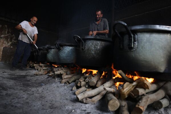 Las personas que se quedaron sin hogar a causa de los bombardeos israelíes cocinan en una hoguera con lo que encuentran entre las ruinas. - Sputnik Mundo