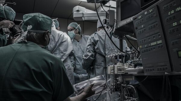 Médicos en un quirófano realizando una cirugía  (imagen referencial) - Sputnik Mundo