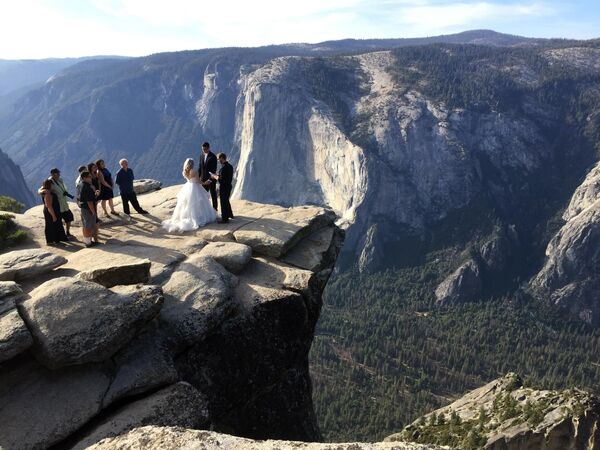 El parque nacional más peligroso es Yosemite, en EEUU, con sus numerosas rocas, acantilados y cascadas. Además, es el hogar de varios cientos de osos negros, a los que atrae el olor a comida de los campamentos turísticos. En el año 2022 fueron 11 personas las que murieron en Yosemite. En la foto: una ceremonia de boda en el acantilado de Taft Point, en el Parque Nacional de Yosemite. - Sputnik Mundo