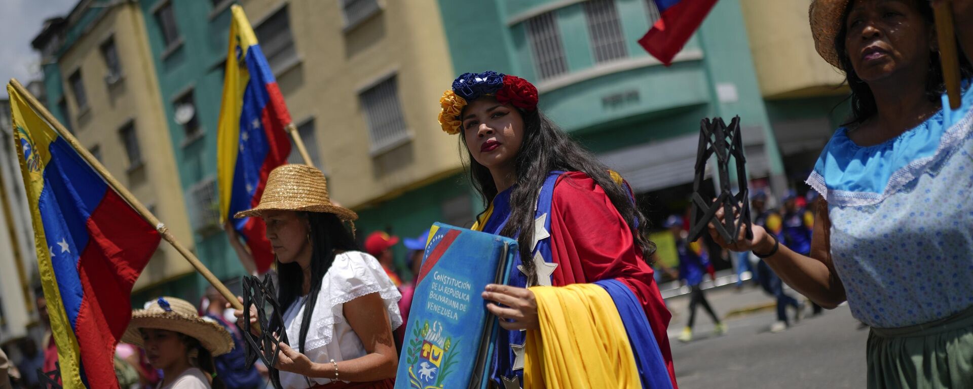 Un manifestante sostiene una copia simulada de la Constitución venezolana durante la marcha Recuperemos el Esequibo - Sputnik Mundo, 1920, 15.11.2023