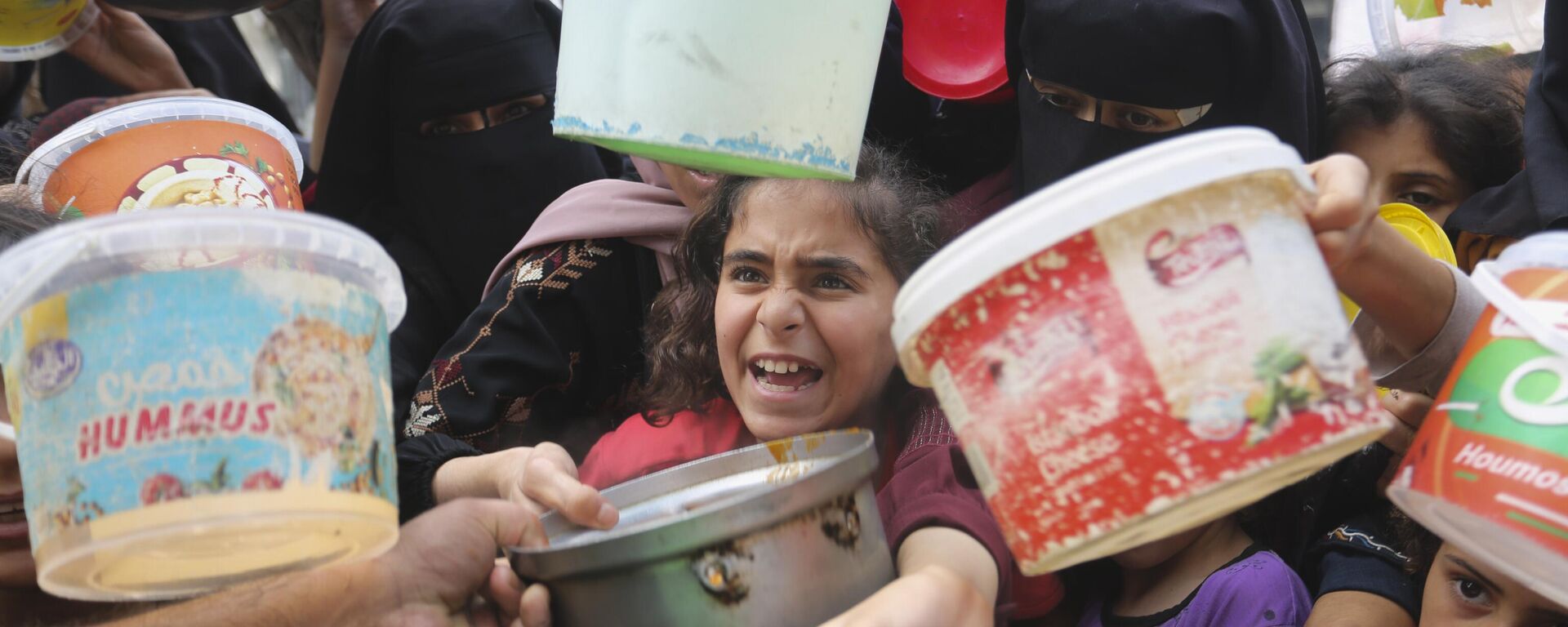Palestinos hacen fila  para conseguir alimentos durante el bombardeo israelí de la Franja de Gaza en Rafah.  - Sputnik Mundo, 1920, 22.12.2023