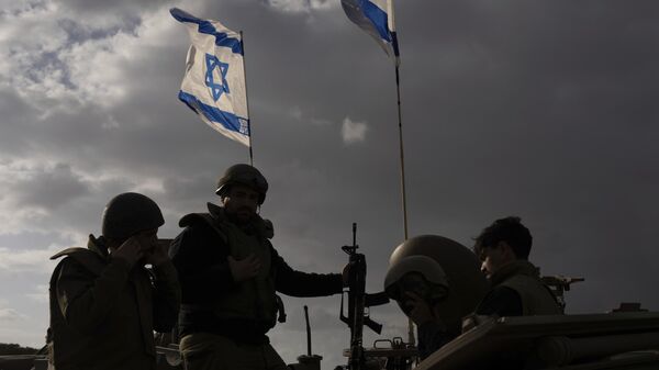 Soldados israelíes trabajando en un vehículo militar blindado a lo largo de la frontera de Israel con la Franja de Gaza - Sputnik Mundo