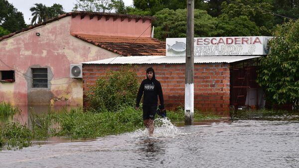 Un hombre vadea el agua en la inundada Ayolas, a 300 km al sur de Asunción (Paraguay), el 3 de noviembre de 2023, tras la crecida del río Paraná por las fuertes lluvias caídas en la región  - Sputnik Mundo