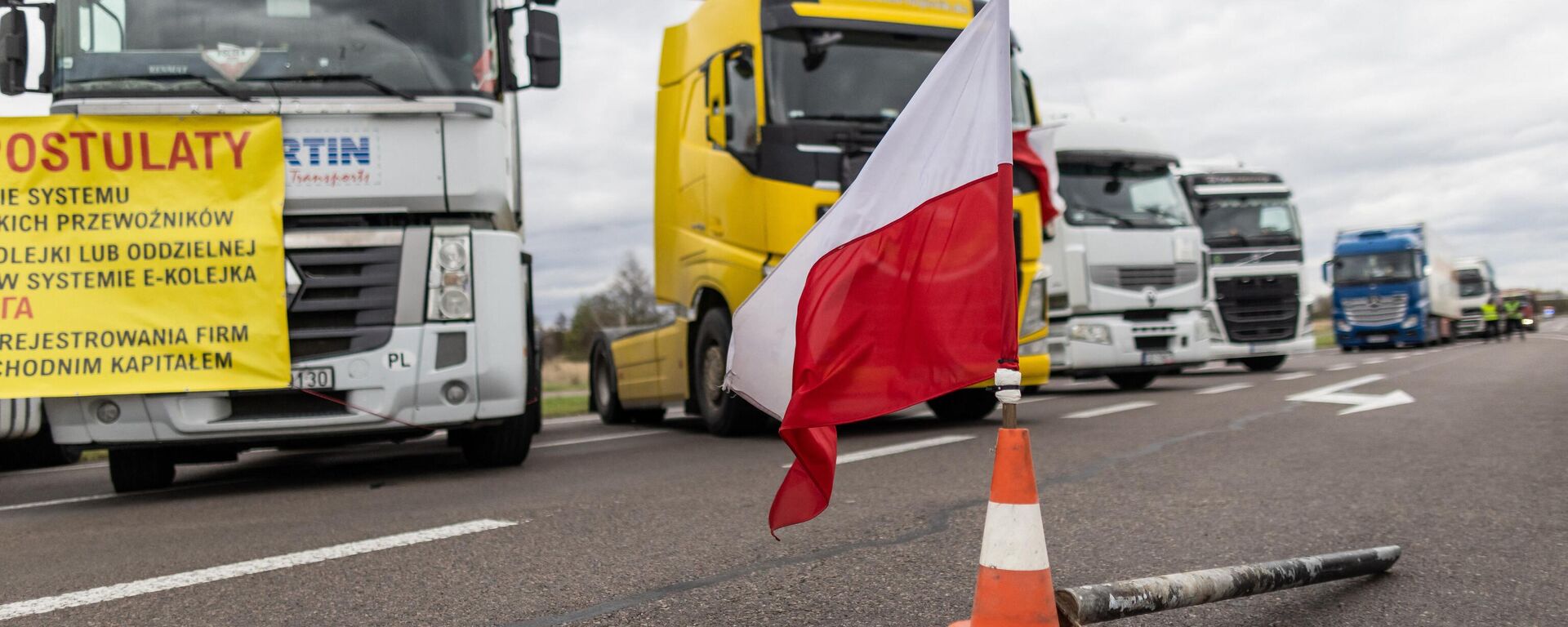 Una bandera polaca en los conos de tráfico durante el bloqueo en la frontera polaco-ucraniana. - Sputnik Mundo, 1920, 01.12.2023