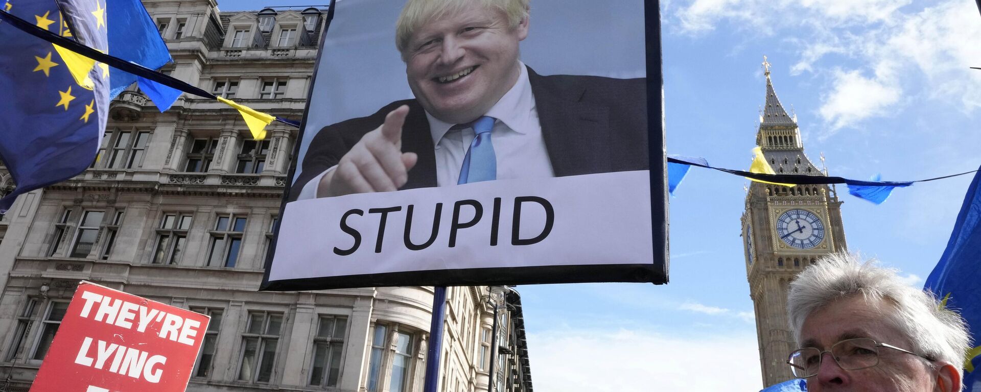 Manifestantes muestran pancartas con el ex primer ministro británico Boris Johnson  - Sputnik Mundo, 1920, 04.12.2023