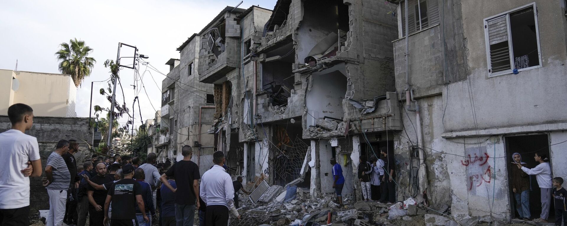 Palestinos inspeccionan un edificio dañado tras una incursión militar israelí en la ciudad de Tulkarem, Cisjordania. - Sputnik Mundo, 1920, 12.12.2023