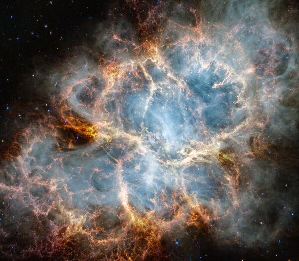 Esta imagen muestra la nebulosa del Cangrejo tomada por el telescopio espacial James Webb. La imagen se asemeja a otra anterior tomada por el telescopio Hubble, en la que Webb pudo ver finas estructuras filamentosas de polvo que emanan del centro de la nebulosa. - Sputnik Mundo