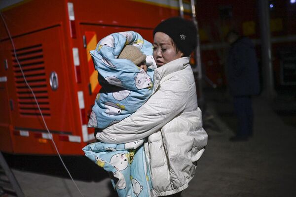 Las autoridades chinas asignaron 200 millones de yuanes (unos 28 millones de dólares) a las provincias afectadas por concepto de ayuda. En la foto: una mujer con un niño en la localidad de Dahejia, en la provincia de Gansu. - Sputnik Mundo