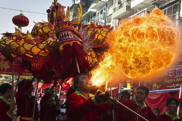 Un dragón sopla llamas mientras un grupo muestra una danza tradicional de este ser mitológico en el primer día del Año Nuevo chino, en la ciudad de Yangón, China. - Sputnik Mundo