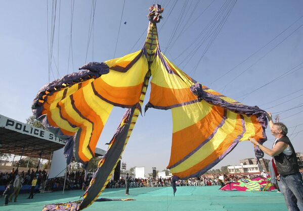 Un alemán vuela una cometa de 16 metros con forma de dragón durante el Festival Internacional de Cometas de Ahmedabad, la India. - Sputnik Mundo