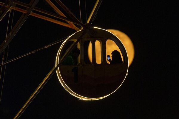 Una cabina de noria con la luna creciente como telón de fondo en Basora, en el sur de Irak. - Sputnik Mundo
