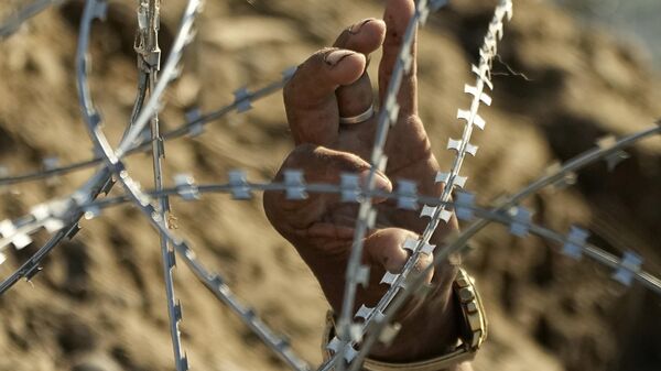 Un migrante intenta cruzar la frontera entre México y Estados Unidos en Eagle Pass, Texas - Sputnik Mundo