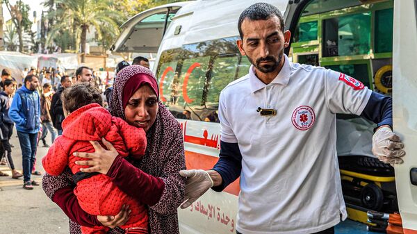 Un paramédico asiste a una mujer que lleva a un niño al llegar al Hospital Europeo de Khan Yunis, en el sur de la Franja de Gaza, el 31 de diciembre de 2023  - Sputnik Mundo