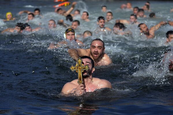Fieles de la Iglesia ortodoxa griega se bañan en la bahía del Cuerno de Oro en Estambul, Turquía, durante la celebración de la Epifanía. - Sputnik Mundo