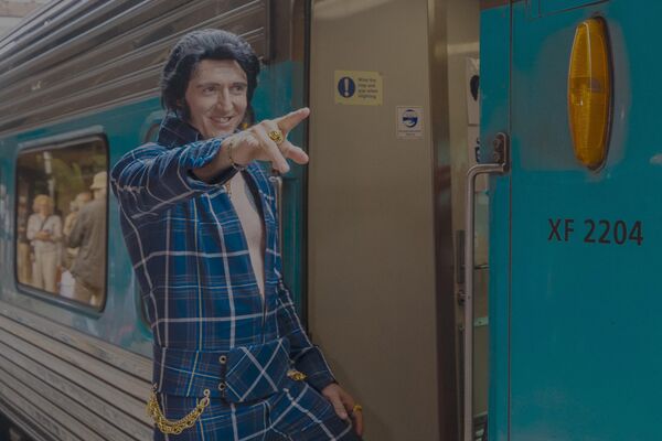 Un imitador de Elvis Presley se dirige al festival anual de Elvis de Parkes, en Nueva Gales del Sur, antes de que el tren salga de la estación central de Sídney, Australia. - Sputnik Mundo