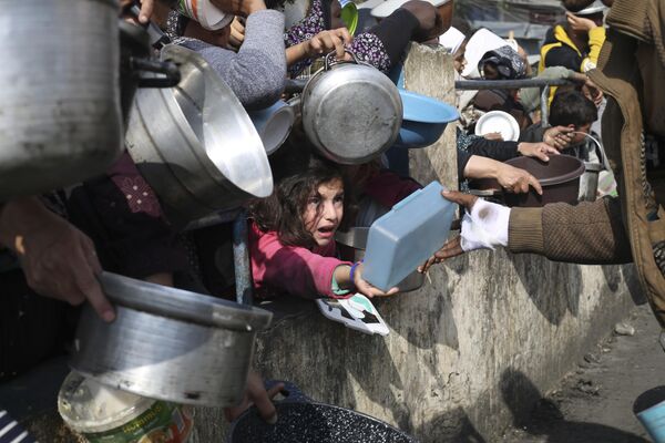 Palestinos haciendo fila para recibir comida gratuita en Rafah, Franja de Gaza. - Sputnik Mundo