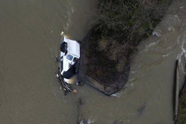 Un barco medio sumergido en el río Támesis durante una inundación en Oxford, Reino Unido. - Sputnik Mundo