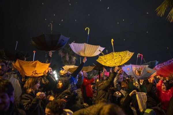 Participantes en el desfile bautismal de la Cabalgata de Reyes en Barcelona, España, cogen caramelos en paraguas boca abajo - Sputnik Mundo