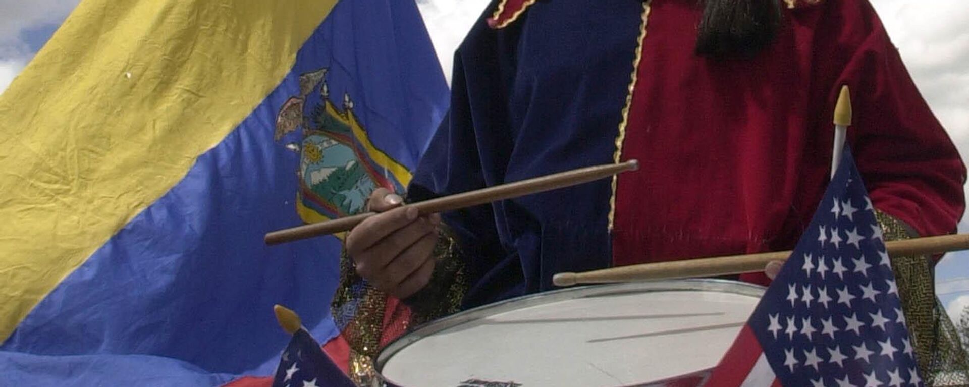 Un actor toca un tambor que tiene dos banderas de EEUU y una de Ecuador - Sputnik Mundo, 1920, 12.01.2024
