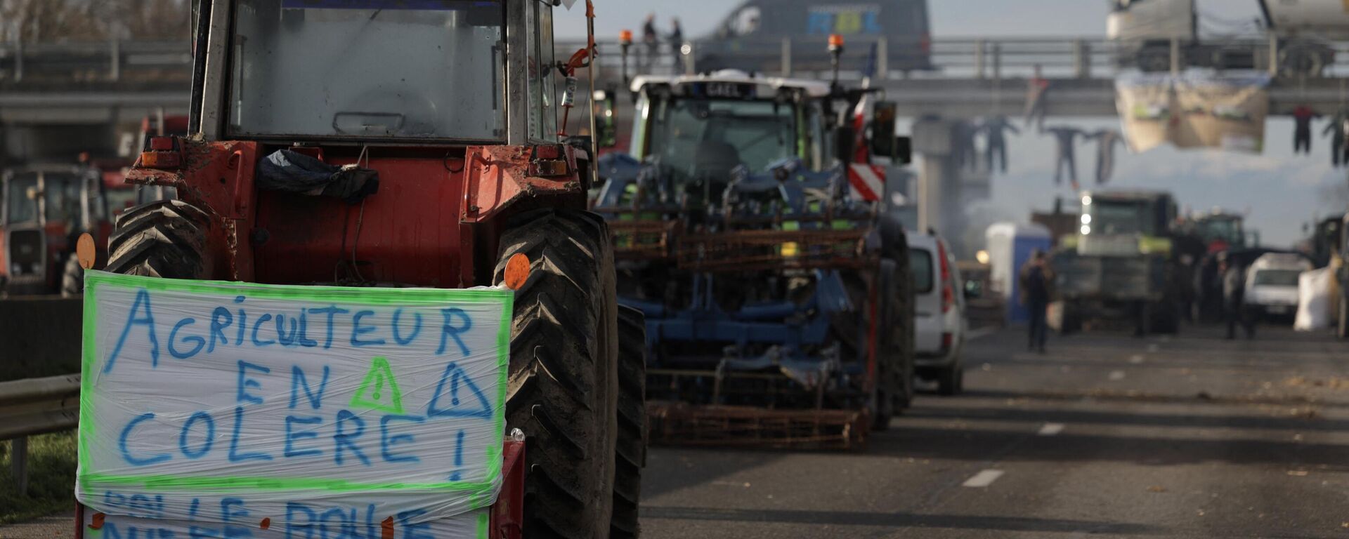Un tractor con una pancarta en la que se lee agricultor enfadado en protesta por los impuestos y la disminución de ingresos, al sur de Toulouse, Francia - Sputnik Mundo, 1920, 24.01.2024
