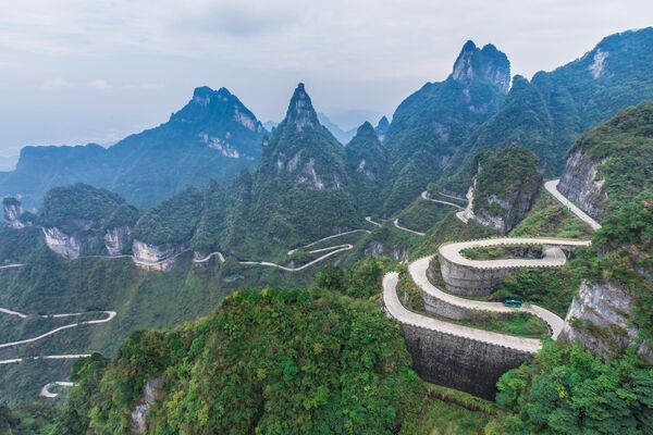 La Carretera de los 99 Giros, que se extiende desde la ciudad china de Zhangjiajie hasta la cima del monte Tianmen, en la provincia de Hunan, también se conoce como la Carretera del Cielo. Su punto más bajo está a 200 metros sobre el nivel del mar y el más alto a 1.300 metros. Hay 99 curvas en el camino hacia el templo en la cima de la montaña. También se puede subir a la montaña a pie, pero para ello hay que subir 999 escalones. - Sputnik Mundo