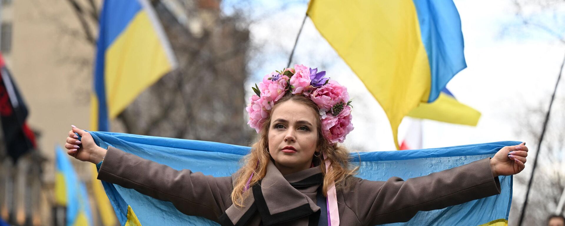 Una manifestante sostiene una bandera ucraniana, el 25 de febrero de 2023  - Sputnik Mundo, 1920, 23.01.2024