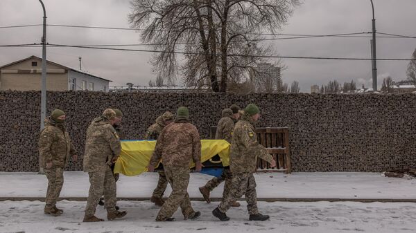 Militares ucranianos cargan un ataúd de uno de sus compañeros, sobre el cual hay una bandera de Ucrania - Sputnik Mundo
