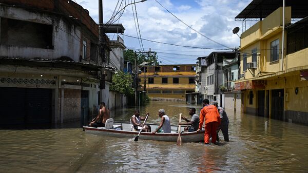Los lugareños navegan en un bote en una zona inundada de la comunidad Lote XV en Belford Roxo, estado de Río de Janeiro, Brasil, el 15 de enero de 2024  - Sputnik Mundo
