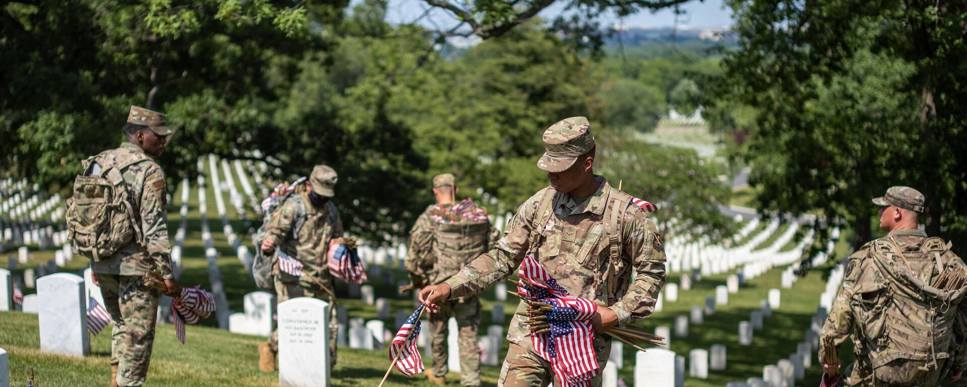 Miembros de las Fuerzas Aéreas colocan banderas estadounidenses en miniatura en las tumbas del Cementerio Nacional de Arlington, en Arlington, el 27 de mayo de 2021  - Sputnik Mundo, 1920, 25.01.2024