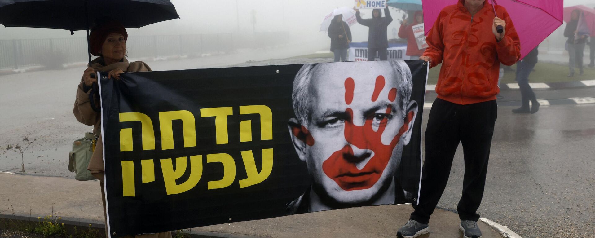 Dos personas se manifiestan en contra de las acciones del primer ministro israelí Benjamín Netanyahu el 23 de enero de 2024 en Moshav Elifelet, al norte de Israel - Sputnik Mundo, 1920, 08.02.2024