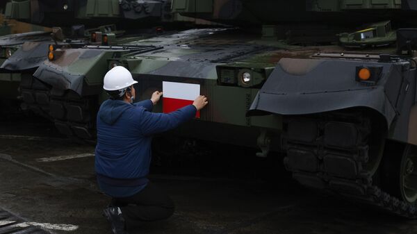 Un empleado coloca una bandera polaca en el tanque surcoreano Black Panther K2 en el puerto de la Armada polaca de Gdynia, Polonia - Sputnik Mundo