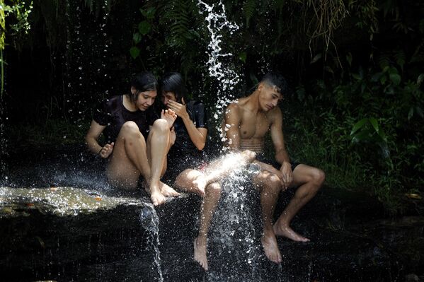Jóvenes se refrescan en un manantial en un caluroso día de verano en Piribebuy, Paraguay. - Sputnik Mundo
