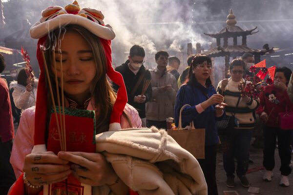 Creyentes quemando incienso en el templo Che Kung de Hong Kong durante la celebración del Año Nuevo Oriental. - Sputnik Mundo