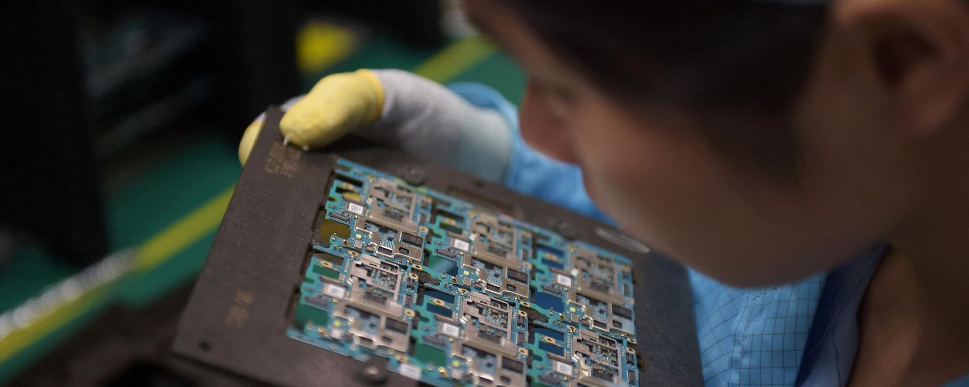 Circuitos de componentes de chips de smartphones son manipulados por un trabajador en la fábrica de Oppo en Dongguan, China  - Sputnik Mundo, 1920, 19.02.2024
