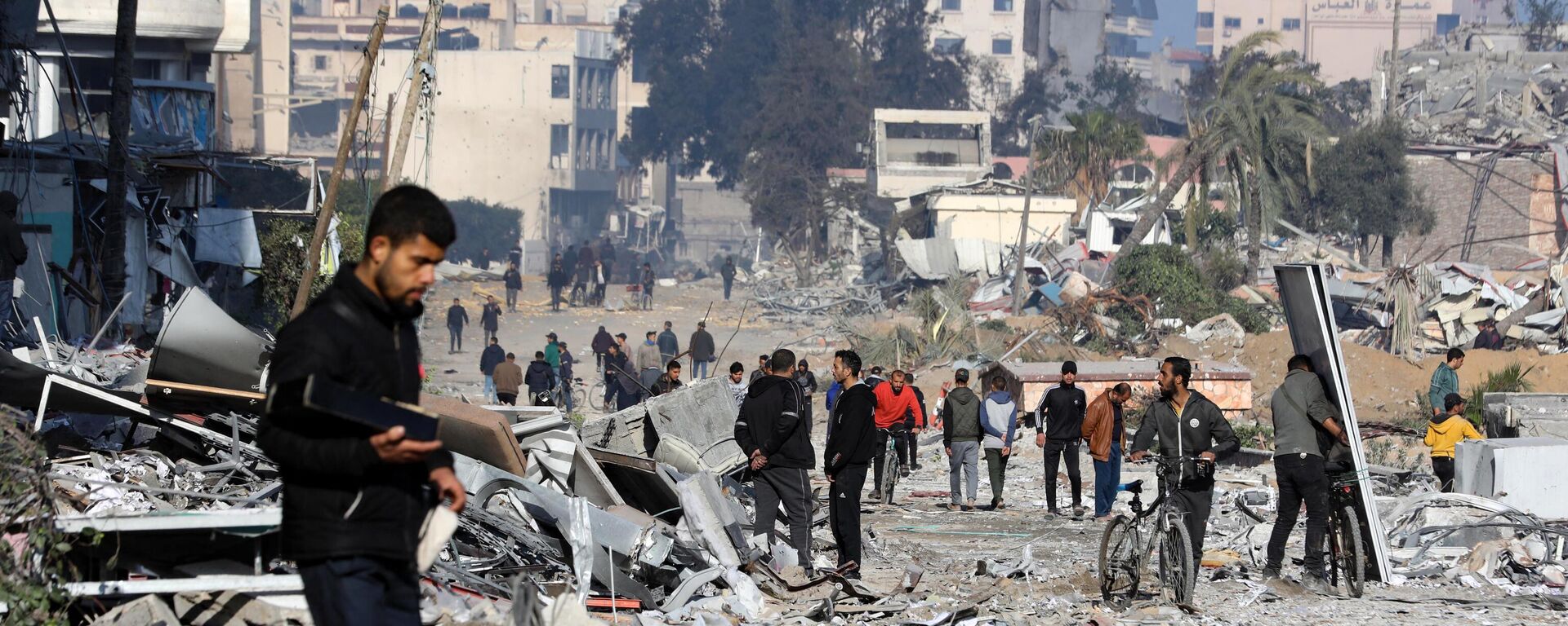 Varias personas caminan por una calle devastada por los ataques israelíes en el barrio de Rimal, en la ciudad de Gaza, el 10 de febrero de 2024  - Sputnik Mundo, 1920, 17.02.2024