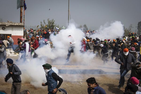Los campesinos que protestaban se dispersan después de que la Policía lanzara gases lacrimógenos en la frontera de Shambhu, a 200 kilómetros de la capital india de Nueva Delhi. - Sputnik Mundo