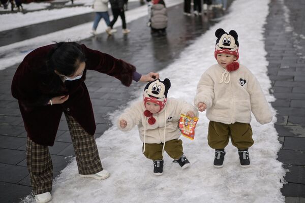 Niños pasean por la ciudad un día después de una nevada en Pekín, China. - Sputnik Mundo
